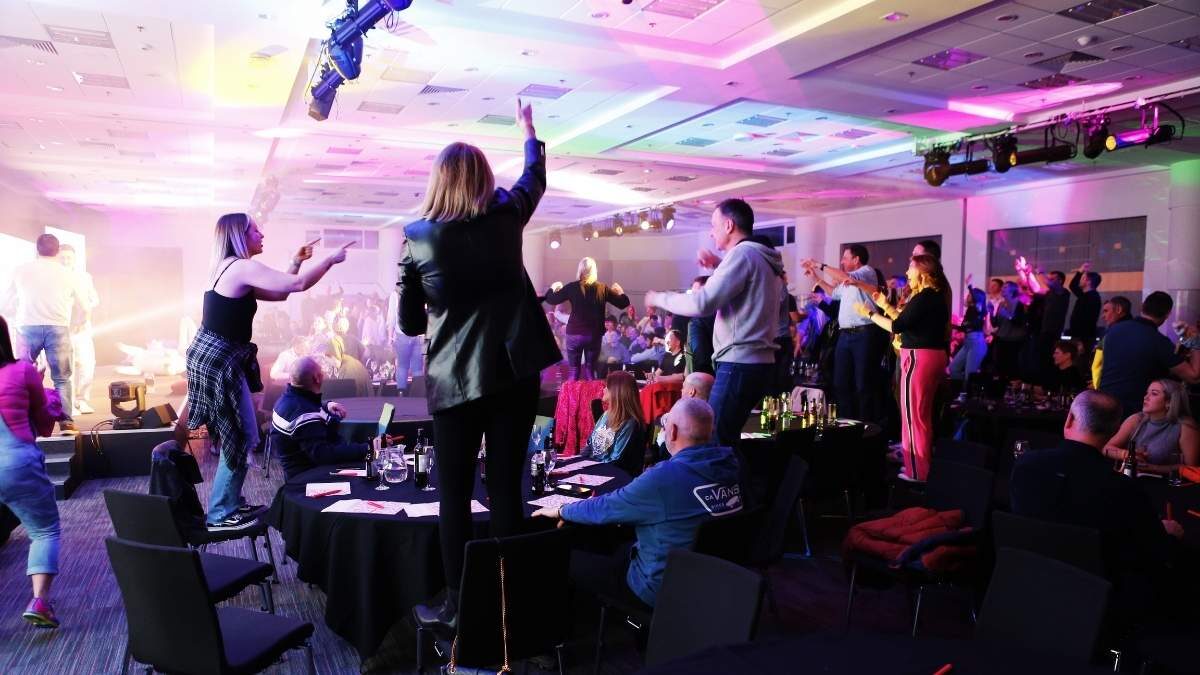 Guests dancing on chairs at a Bing-E-Oke party